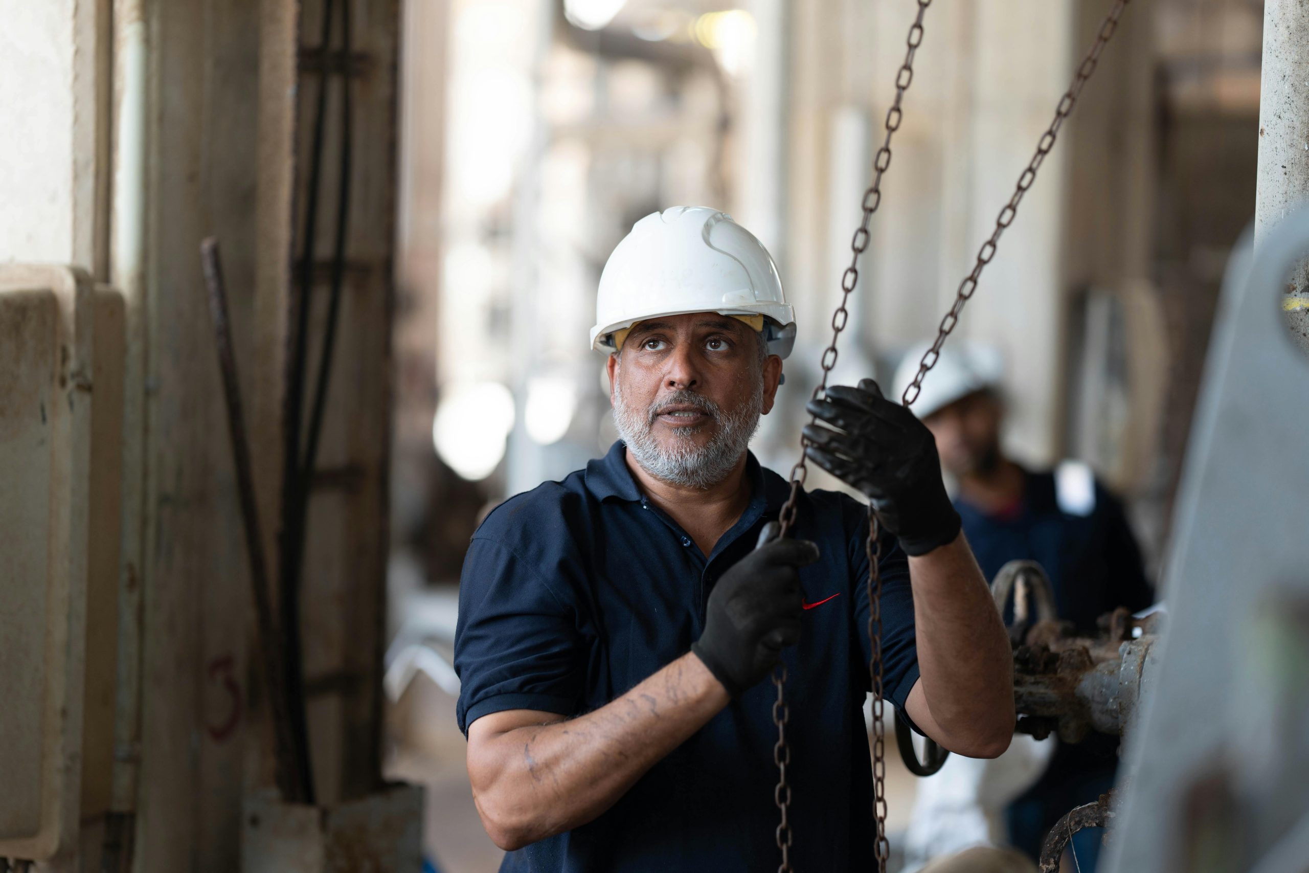 A construction worker in Libya operating machinery with focus and precision.